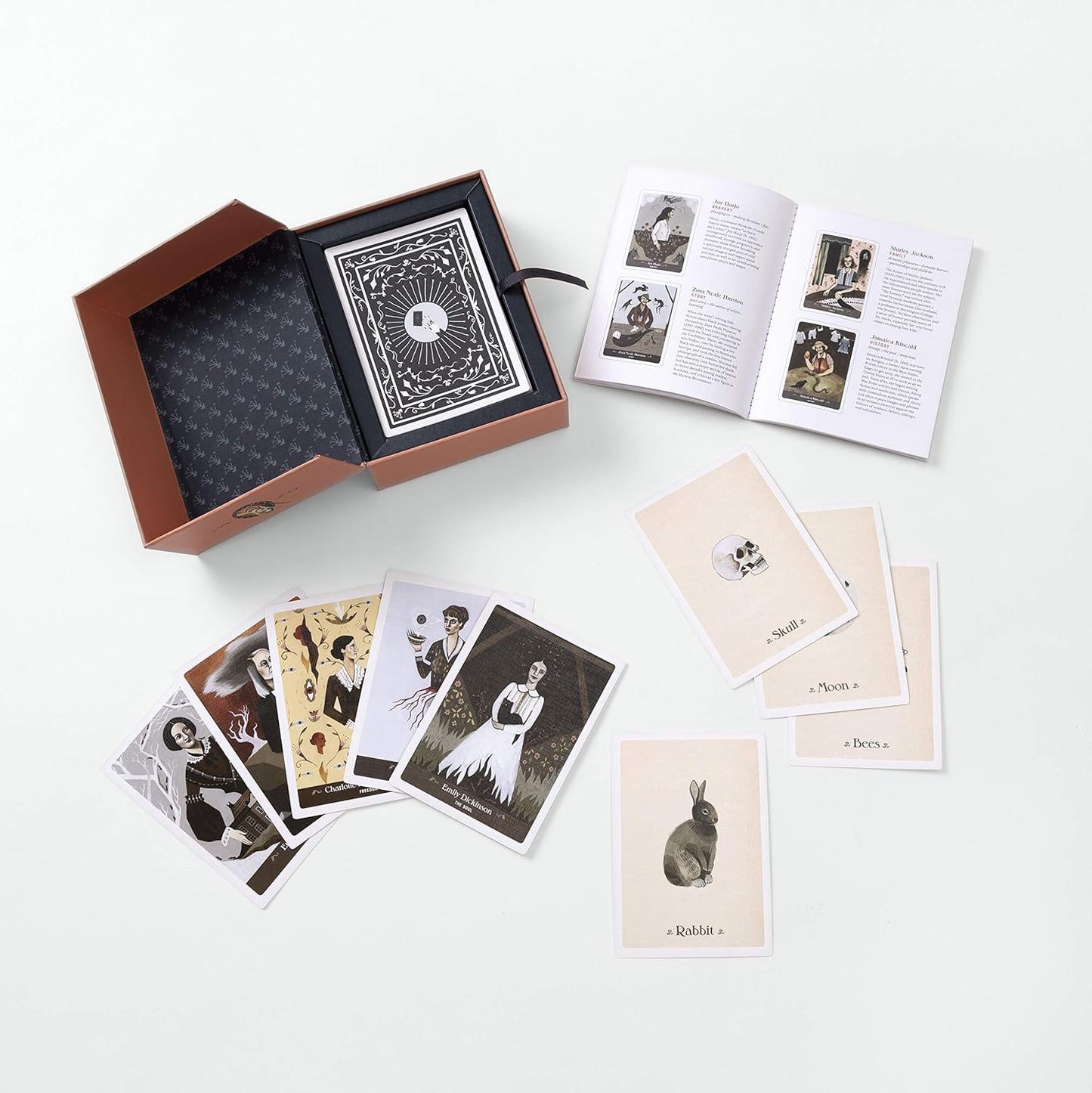 Collection of playing cards and a book on a white surface