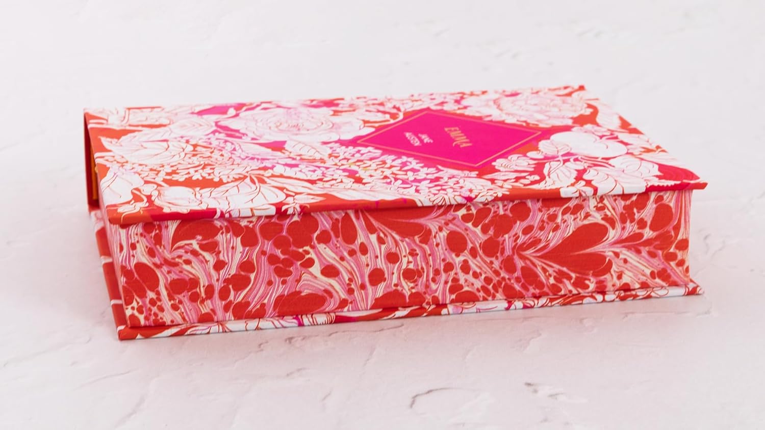 Decorative box with red and white floral pattern on a light gray background