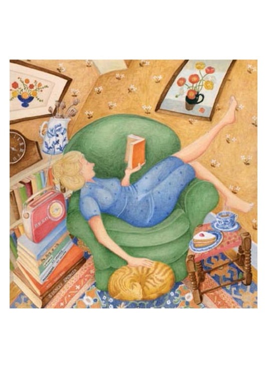 An image of a lady on a green chair reading a book